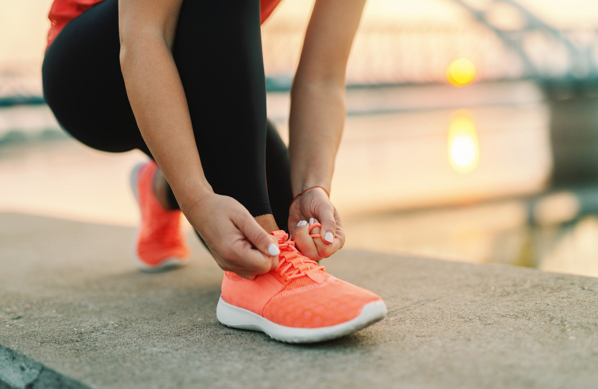 Sporty women tying tennis shoe